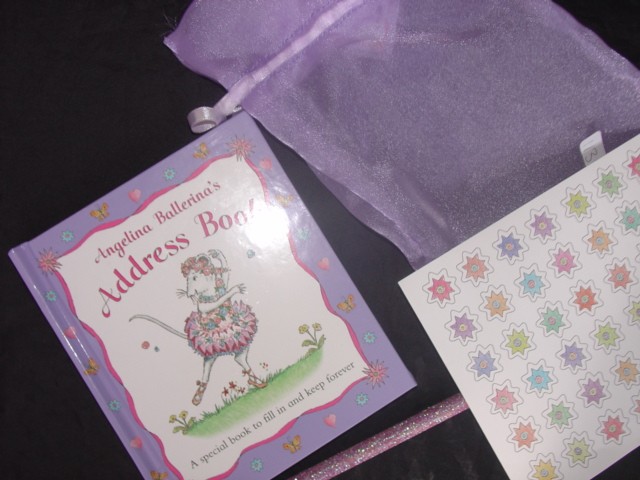 A HARDBACK ADDRESS BOOK WITH A PICTURE OF A MOUSE IN A TUTU ON THE FRONT. PACKAGED WITH THE ADDRESS BOOK IS A PAGE OF STICKERS AND A PENCIL DECORATED WITH GLITTER WITH A RUBBER AT THE END. ALL ITEMS ARE PRESENTED IN A DRAWSTRING ORGANZA BAG WHICH IS SECURED WITH A TAG. THE ESSENTIAL CHARACTER IS GIVEN BY THE ADDRESS BOOK.