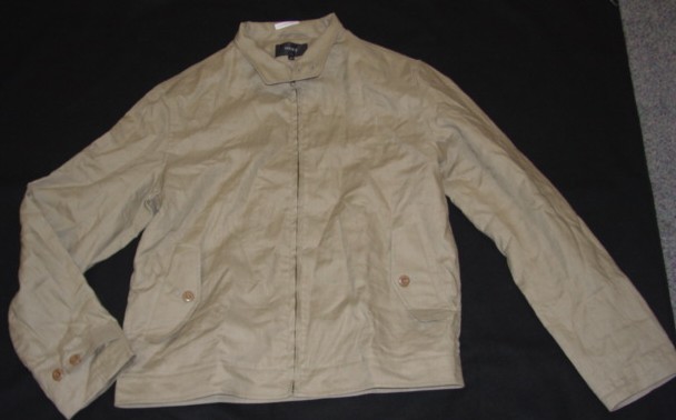 A WOVEN JACKET FOR MEN. DESIGNED TO COVER THE UPPER PART OF THE BODY FROM THE SHOULDERS TO JUST BELOW THE WAIST. WITH A COMPLETE FRONT OPENING FASTENED BY A ZIP. WITH ROUND NECK. WITH COLLAR WHICH HAS A FLAP WHICH FASTENS LEFT OVER RIGHT WITH TWO BUTTONS. WITH LONG SLEEVES WHICH HAVE BUTTON TAB ADJUSTERS AT SLEEVE ENDS. WITH LINING. WITH TWO POCKETS ON LOWER FRONT OF GARMENT AND ONE INNER POCKET. HEMMED AT SLEEVE ENDS AND AT BASE OF GARMENT. MADE FROM 100% LINEN.