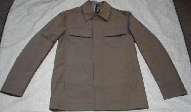 A WOVEN CASUAL JACKET FOR MEN. REACHING TO THE HIP. WITH A COMPLETE OPENING WITH A CONCEALED LEFT OVER RIGHT BUTTON CLOSURE. WITH LONG SLEEVES. HEMMED AT SLEEVE ENDS AND BASE OF GARMENT. WITH TWO CHEST POCKETS WITH BUTTON FLAPS, AND TWO SLIT POCKETS TO LOWER FRONT. FULLY LINED. 100% COTTON HERRINGBONE WEAVE.