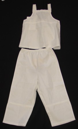 A WOVEN ENSEMBLE FOR GIRLS. THE UPPER GARMENT IS IN THE FORM OF A BLOUSE REACHING FROM THE SHOULDERS TO BELOW THE WAIST. WITHOUT SLEEVES. WITH SHOULDER STRAPS. WITHOUT OPENING OR FASTENING. WITH FRILLING AROUND FRONT AND STRAPS OF GARMENT. ELASTICATED AT THE BACK. HEMMED AT BASE OF GARMENT. LOWER GARMENT IS A PAIR OF TROUSERS WHICH REACH FROM THE WAIST TO THE ANKLES ENVELOPING EACH LEG SEPARATELY. WITH AN ELASTICATED WAIST. WITHOUT OPENING OR FASTENING. HEMMED AT LEG ENDS. BOTH GARMENTS ARE MADE OF THE SAME FABRIC AND MATCHING IN COLOUR AND DESIGN. MADE FROM 100% COTTON.