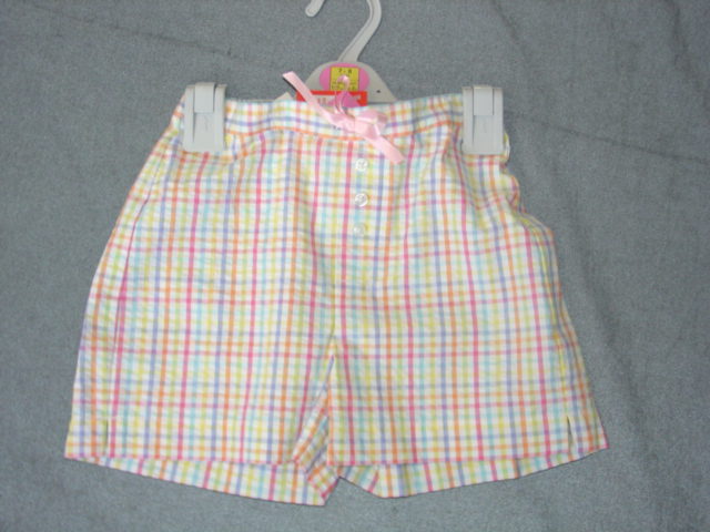 WOVEN SHORTS FOR UNISEX. REACHING DOWN TO ABOVE THE KNEE ELASTICATED WAIST WITHOUT OPENING. WITH MOCK BUTTON FLY. DECORATIVE RIBBON TIE AT FRONT.  HEMMED AT LEG ENDS WITH SMALL VENT IN SIDE SEAMS. MULTI CHECK DESIGN. 100% COTTON.  PACKED ON PLASTIC HANGER IN PLASTIC BAG.