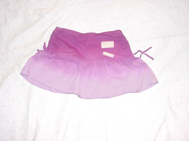 A KNITTED SKIRT. DESIGNED TO COVER THE LOWER PART OF THE BODY. WITH AN ELASTICATED WAISTBAND. WITHOUT AN OPENING. WITH DECORATIVE TIES AT THE SIDES. HEMMED. 100% COTTON.