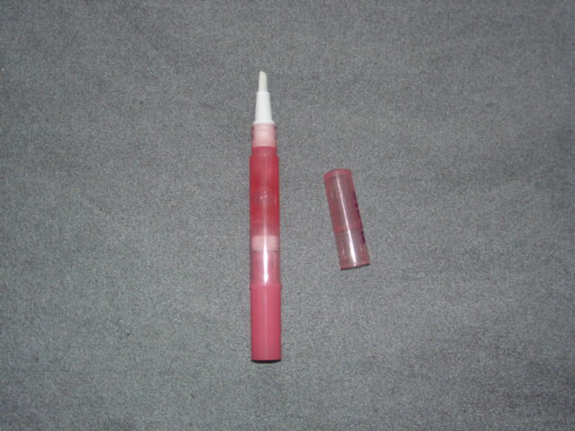 LIP GLOSS IN A PENCIL SHAPED PLASTIC CONTAINER.  PRESENTED TOGETHER  IN PLASTIC PACKAGING WITH A MIRROR CLASSIFIED SEPARATELY.