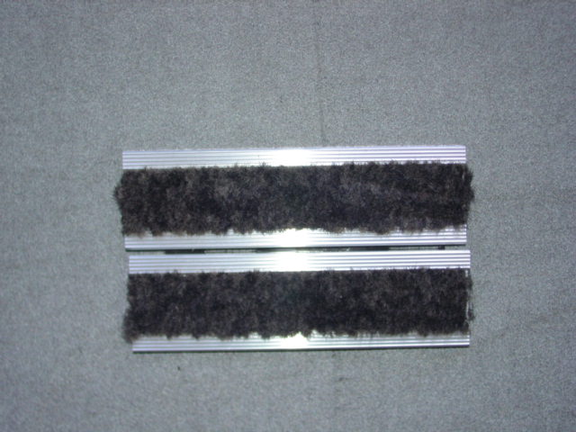 A FLOORING MADE UP OF ALUMINIUM EXTRUDED INTERLOCKING CHANNELS WITHIN WHICH IS FULLY ADHEREED A WOVEN POLYPROPYLENE CARPET STRIP, MADE UP OF BOTH ABSORBING AND SCRAPING STRIPS.