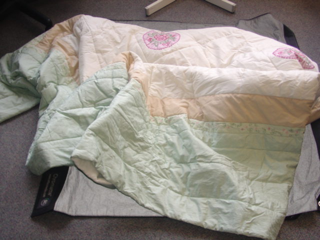 A WOVEN SLIGHTLY PADDED QUILTED BEDSPREAD OF 50% POLYESTER / 50% COTTON. FOR A DOUBLE BED. MADE OF SEVERAL DIFFERENT PRINTED AND EMBROIDERED FABRICS, WITH APPLIQUE AND BEADWORK. PACKAGED IN A CLEAR PLASTIC BAG WITH TETXILE HANDLES.