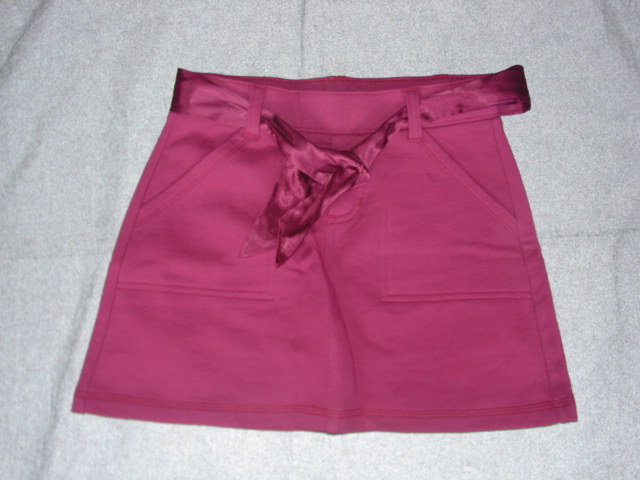 KNITTED SKORT FOR GIRLS.  OUTER LAYER IS A SKIRT, WITH SHORTS ATTACHED BENEATH.  WITH MOCK FLY. WITH POCKETS.  HEMMED AT BASE. WITH EMBOIDERED BUTTERFLY DESIGN ON BACK POCKET.  PACKED WITH MATCHING BELT OF COORDINATING COLOUR FABRIC. 100% COTTON.