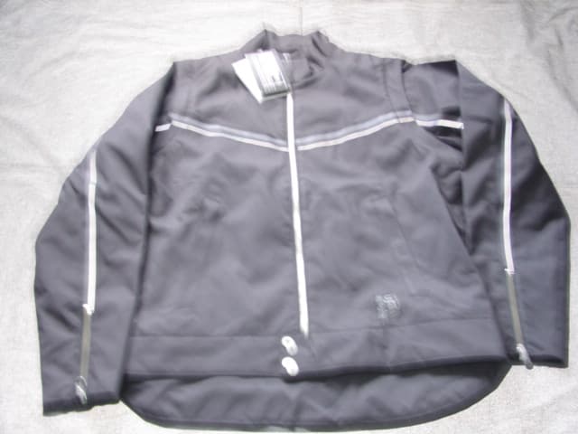 WOVEN JACKET FOR MEN.  REACHING DOWN TO BELOW THE WAIST.  WITH NON VISIBLE PU COATING ON INNER SURFACE. WITH MESH LINING. ROUND NECK WITH COLLAR.  COMPLETE FRONT OPENING FASTENED LEFT OVER RIGHT BY ZIP WITH PRESS STUD FLAPS AT TOP AND BASE.  APPLIED BAND AT BASE, WITHOUT TIGHTENING.  LONG SLEEVES.  WITH ZIPS AT SLEEVE ENDS.  WITH POCKETS.  OF NYLON.  PACKED IN PLASTIC BAG.
