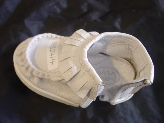 TODDLERS ANKLE BOOT. COVERS THE ANKLE BUT NO PART OF THE CALF. LEATHER UPPERS AND RUBBER OUTER SOLE. BOOT FASTENS WITH A ZIP THAT RUNS DOWN ONE SIDE OF THE BOOT AND ACROSS THE BOTTOM OF THE SOLE. BOOT HAS A FRINGE OF LEATHER AROUND THE ANKLE. INSOLE MEASURES LESS THAN 24CM. NO EVIDENCE OF SPECIAL TECHNOLOGY IN THE SOLE. WILL BE PACKAGED IN A SOFT PLASTIC POUCH.
