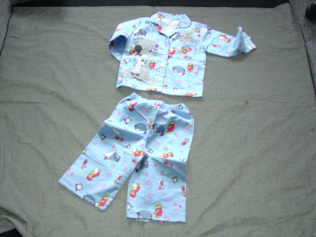 A PAIR OF WOVEN BRUSHED COTTON PYJAMAS FOR GIRLS. JACKET HAS A REVER COLLAR WITH A RIGHT OVER LEFT BUTTON FASTENING. WITH A BREAST POCKET. WITH LONG SLEEVES. HEMMED AT SLEEVE ENDS AND BASE OF GARMENT. WITH RIBBON TRIM TO SLEEVE ENDS AND BASE OF JACKET. TROUSERS HAVE AN ELASTICATED WAIST AND HEMMED LEG ENDS. WITH AN ALL OVER PRINT WITH EMBROIDERED APPLIQUE TO FRONT.