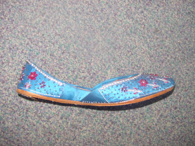 LADIES SLIP ON STYLE SHOE. UPPERS OF SATIN WITH SEQUIN AND BEAD FLORAL PATTERN. WITH LEATHER LINING. OUTER SOLES OF LEATHER. WITH SMALL HEEL. BLUE IN COLOUR.