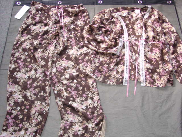 A WOVEN ENSEMBLE FOR WOMEN. THE UPPER IS A JACKET STYLE GARMENT. WITH LONG SLEEVES, WITH A RIBBON TIE FASTENING AT THE CENTRE OF THE GARMENT. WITH APPLIED LACE AT SLEEVE ENDS,  AT THE OPENING AND AT THE BASE OF THE  GARMENT. THE LOWER GARMENT IS A PAIR OF TROUSERS. IN MATCHING FABRIC AS THE UPPER GARMENT ENVELOPING EACH LEG SEPARATELY. WITH AN ELASTICATED WAISTBAND AND RIBBON DRAWSTRING. WITH SLITS AT LEG ENDS WITH LACE TRIM. 100% POLYESTER.