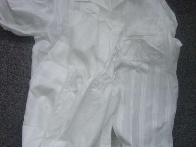 A PAIR OF WOVEN PYJAMAS FOR LADIES. THE UPPER GARMENT IS A PYJAMA STYLE JACKET. DESIGNED TO COVER THE UPPER PART OF THE BODY FROM THE SHOULDERS TO THE UPPER THIGH. BUTTON FASTENING WITH POCKETS AND LONG SLEEVES. WITH COLLAR. THE LOWER GARMENT IS A PAIR OF LOOSE FITTING TROUSERS DESIGNED TO COVER THE LOWER PART OF THE BODY FROM THE WAIST TO THE ANKLES ENVELOPING EACH LEG SEPARATELY.  WITH A PARTIALLY ELASTICATED WAISTBAND AND A DRAWSTRING TIE. RIBBON THREADED THROUGH THE TROUSER BOTTOMS. PACKAGED FOR RETAIL SALE. 100% COTTON.