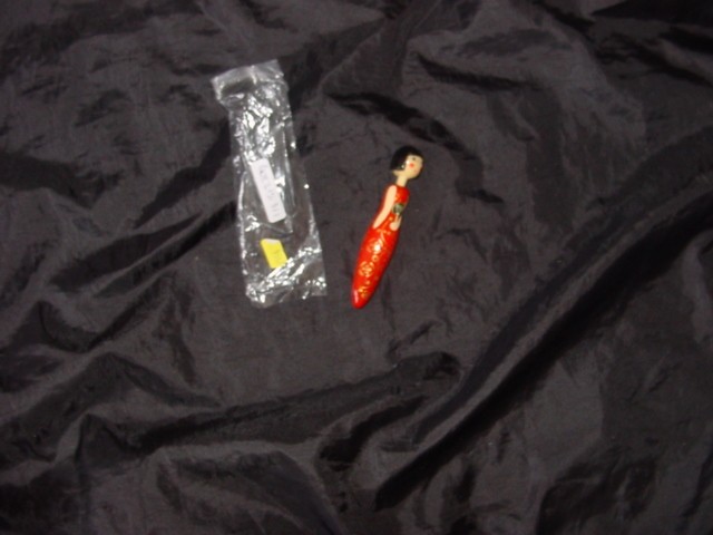 NOVELTY BALLPOINT PEN. OF PLASTIC. THE PEN IS IN THE SHAPE OF A CHINESE GIRL. WHEN HER HEAD IS PRESSED DOWN THE THE NIB IS RELEASED.REFILLABLE.WITH LIQUID INK.PACKAGED FOR RETAIL SALE IN A PLASTIC BAG.