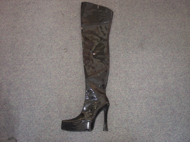 THIGH HIGH FASHION BOOT. UPPERS OF PLASTIC. WITH FULL LENGTH ZIP FASTENING DOWN ONE SIDE. OUTER SOLES OF RUBBER. WITH THICK PLATFORM SOLE AND HIGH HEEL (MEASURING 14CMS). BLACK IN COLOUR.