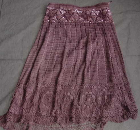 A CROCHETED SKIRT FOR WOMEN. DESIGNED TO COVER THE LOWER PART OF THE BODY FROM THE WAIST TO JUST ABOVE THE ANKLES. WITH INNER KNITTED LINING. MADE FROM 100 PER CENT VISCOSE. WITH SEQUIN AND BEAD DESIGN AROUND THE WAIST. WITH AN ELASTICATED WAIST. PACKAGED IN A CLEAR PLASTIC BAG WITH CARDBOARD INSERT.