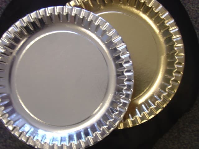 PLATES MADE OF PAPER. THE PLATES HAVE FLUTED EDGES AND ARE GOLD OR SILVER IN COLOUR.