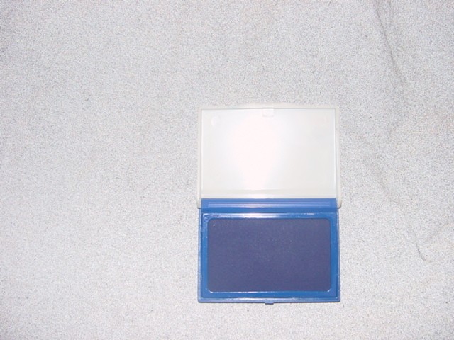 AN INKED PAD CONSISTING OF ABSORBENT MATERIAL CONTAINED IN A PLASTIC BOX. MEASUREMENTS ARE APPROX  10CM X 7CM.
