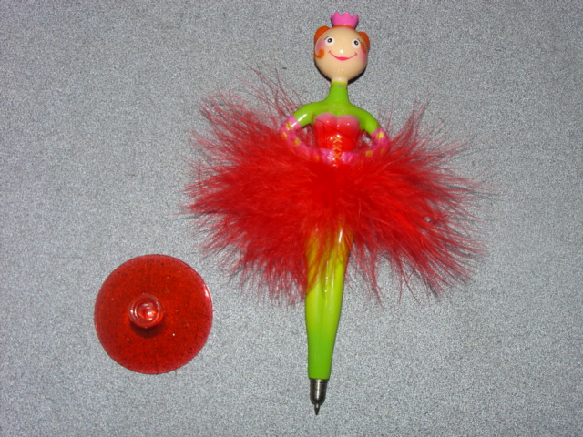 BALLERINA BALLPOINT PEN. ROLLER BALL WITH LIQUID INK. REFILLABLE. OF PLASTIC. IN THE SHAPE OF A BALLERINA. WITH FEATHER SKIRT. FITS INTO A PLASTIC SUCKER TO MAKE IT STAND UP. PACKAGED FOR RETAIL SALE IN A CYLINDRICAL PLASTIC CASE.