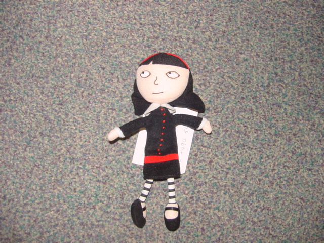 STUFFED TEXTILE DOLL. REPRESENTING A GIRL DRESSED IN A BLACK DRESS AND BLACK AND WHITE STRIPED TIGHTS. MEASURES APPROX 20 CMS HIGH.