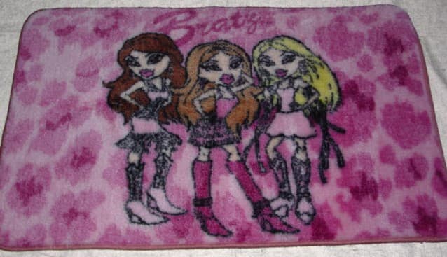 A TUFTED CUT PILE RUG MEASURING 57 CMS. X 90 CMS. APPROX.  WITH A RUBBER BACKING.  WITH A PRINTED DESIGN.  BOUND AT EDGES.  100 PERCENT NYLON.