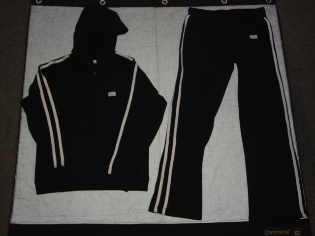 A KNITTED TRACKSUIT FOR UNISEX  CONSISTING OF AN UPPER AND LOWER GARMENT. THE UPPER GARMENT HAS A COMPLETE OPENING AT THE FRONT FASTENED WITH A ZIP. WITH A HOOD.  WITH LONG SLEEVES WITH RIBBED CUFFS AND TWO CONTRASTING STRIPES RUNNING FROM THE TOP OF THE SHOULDER DOWN EACH ARM. WITH A POCKET ON EACH FRONT PANEL AND RIBBING TO BASE OF GARMENT. WITH INNER SURFACE NAPPED. THE LOWER GARMENT IS A PAIR OF LOOSE FITTING TROUSERS WHICH ENVELOP EACH LEG SEPARATELY TO THE ANKLE. WITH  A RIBBED ELASTICATED WAIST WITHOUT OPENING AND  WITH A DRAWSTRING TIE. HEMMED. WITH TWO HIP POCKETS AND A BACK POCKET WITH A ZIP CLOSURE. WITH TWO CONTRASTING STRIPES DOWN EACH OUTSIDE LEG. WITH INNER SURFACE NAPPED.  65 PER CENT POLYESTER, 35 PER CENT COTTON.