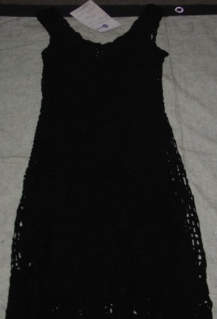 A HAND MADE TAPE RIBBON DRESS FOR WOMEN. DESIGNED TO COVER THE WHOLE OF THE BODY FROM THE SHOULDERS REACHING DOWN BELOW THE KNEE. WITHOUT SLEEVES. WITHOUT OPENING. WITH INNER LINING MADE OF 100 PER CENT POLYESTER. GARMENT IS  MADE FROM A MESH STYLE FABRIC 100 PER CENT VISCOSE CONSTRUCTED BY STITCHED OVERLAPPING TAPE RIBBON TOGETHER AT INTERVALS.