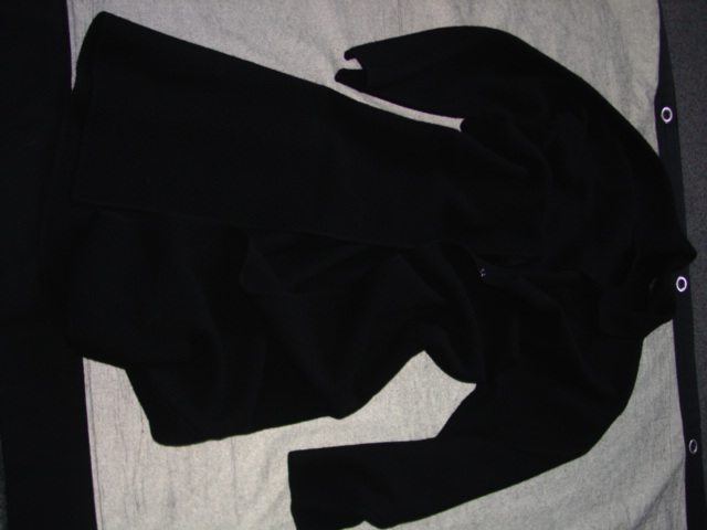 KNITTED COAT FOR WOMEN.  REACHING DOWN TO BELOW THE KNEE.  V-NECK WITH COLLAR.  COMPLETE FRONT OPENING WITH EDGES MEETING AND FASTENED BY HOOKS AND EYES.  LONG SLEEVES.  OVERSEWN AT SLEEVE ENDS AND AT BASE.  WITH POCKETS.  100 PERCENT BOILED WOOL