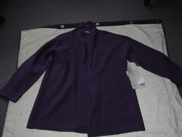A KNITTED OVERCOAT FOR UNISEX. DESIGNED TO COVER THE WHOLE OF THE BODY FROM THE SHOULDERS REACHING DOWN TO BELOW THE KNEE. WITH A REVER COLLAR. WITH LONG SLEEVES WITH TURN BACK CUFFS. WITH COMPLETE OPENING. UNLINED. OVERLOCKED AT EDGES. GARMENT IS MADE FROM 100 PER CENT BOILED WOOL.