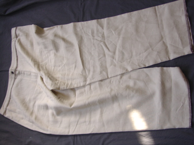 WOVEN TROUSERS FOR WOMEN.  REACHING DOWN TO THE ANKLE.  WITH ZIP FLY FASTENING RIGHT OVER LEFT BY BUTTON AT WAIST.  OVERSEWN AT LEG ENDS, WAISTBAND AND SIDE SEAMS BY CONTRASTING YARN.  100 PERCENT LINEN