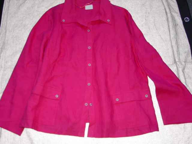 WOVEN JACKET FOR WOMEN. REACHING DOWN TO BELOW THE WAIST.  V NECK WITH COLLAR.  COMPLETE FRONT OPENING FASTENED RIGHT OVER LEFT BY PRESS STUDS.  LONG SLEEVES.  HEMMED AT SLEEVE ENDS AND AT BASE.  WITH POCKETS ON LOWER FRONT.  100 PERCENT LINEN