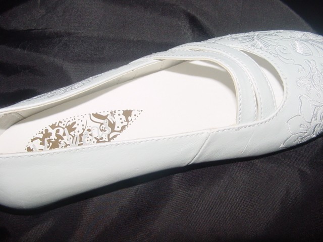 A LADIES LEATHER SHOE WITH A SOLE OF PLASTIC/RUBBER AND AN EVA MIDSOLE. THERE ARE TWO STRAPS PLACED DIAGONALLY ACROSS THE FOOT AND A LOOP AT THE BACK. THERE IS A PATTERN ON THE FRONT AND SIDE OF THE SHOE. IN-SOLE LENGTH IS 24CMS. NOT COVERING THE ANKLE.