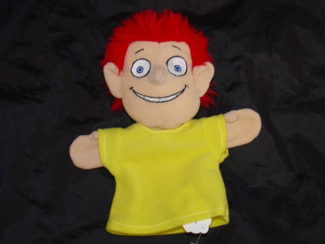 HAND PUPPET TOY FOR CHILDREN IN THE FORM OF A HUMAN BEING. MADE OF TEXTILE MATERIAL. THE HEAD IS STUFFED AND THE BODY IS NOT, TO ALLOW SPACE TO PUT A HAND INSIDE. THE FACE IS HUMAN LOOKING,  AND HAS RED HAIR. THE BODY HAS ARMS AND IT IS DRESSED IN A YELLOW T-SHIRT