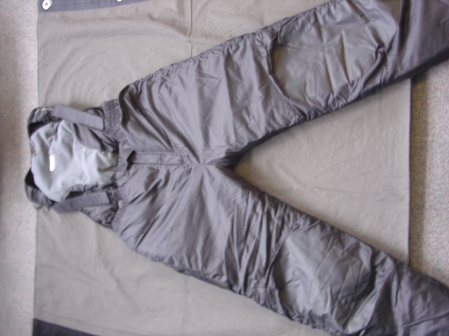 A PAIR OF WOVEN SALOPETTES FOR MEN COVERING THE BODY FROM THE SHOULDERS TO THE ANKLE, ENVELOPING EACH LEG SEPARATELY. WITH TWO ADJUSTABLE BRACES THAT FIT OVER THE SHOULDERS. WITH A BACK PANEL. ELASTICATED AT THE WAIST WITH A LEFT OVER RIGHT PRESS-STUD FASTENING. ELASTICATED AT LEG ENDS WITH A ZIP AND PRESS-STUD FASTENING. WITH REINFORCE SEAT AND KNEE PANELS LINED. WITH AN INNER WADDING. 100 PER CENT NYLON.