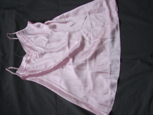 A WOVEN SATIN PETTICOAT FOR WOMEN. DESIGNED TO COVER THE UPPER PART OF THE BODY FROM THE SHOULDERS TO MID THIGH. WITH THIN ADJUSTABLE SHOULDER STRAPS. WITH A V-NECKLINE. HEMMED AT BASE. 100 PER CENT POLYESTER. PACKAGED IN A POLY BAG WITH CARD SLEEVE. 100 PER CENT POLYESTER.