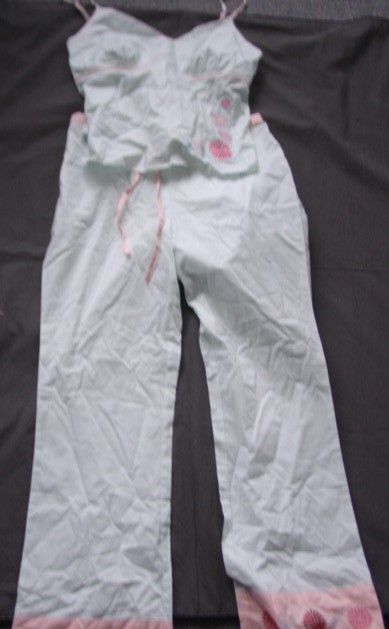 A WOVEN PAIR OF PYJAMAS FOR WOMEN. CONSISTING OF A UPPER GARMENT. WITH THIN ADJUSTABLE SHOULDER STRAPS. WITH A  V NECKLINE. WITH EMBROIDERY ON LEFT HAND SIDE.  THE LOWER IS A PAIR OF FULL LENGTH  TROUSERS, ENVELOPING EACH LEG SEPARATELY. WITHOUT AN OPENING WITH ELASTICATION AT BACK OF WAIST AND A DRAWSTRING TIE.  WITH EMBROIDERY ON LOWER LEGS.  HEMMED.  OF COTTON. PACKAGED TOGETHER ON A HANGER FOR RETAIL SALE.
