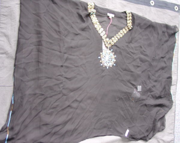 A WOVEN KAFTAN STYLE CHIFFON BLOUSE FOR WOMEN.  DESIGNED TO COVER THE BODY FROM THE SHOULDERS TO THE THIGH.  WITH A V NECK WITHOUT OPENING.  THE GARMENT IS MADE FROM ONE PIECE OF FABRIC AND HAS VERTICAL STITCHING IN THE CENTRE EACH SIDE SO THE ARMS MAY GO THROUGH TO GIVE SLEEVE EFFECT.  WITH A METAL AND COLOURED BEAD DECORATION AROUND NECK AND ON UPPER FRONT.  SMALL BEAD AND SEQUIN DECORATION ALONG SIDE EDGES.  HEMMED AT BASE.  100 PERCENT SILK.  PACKAGED IN A SEE THROUGH BAG FOR RETAIL SALE.