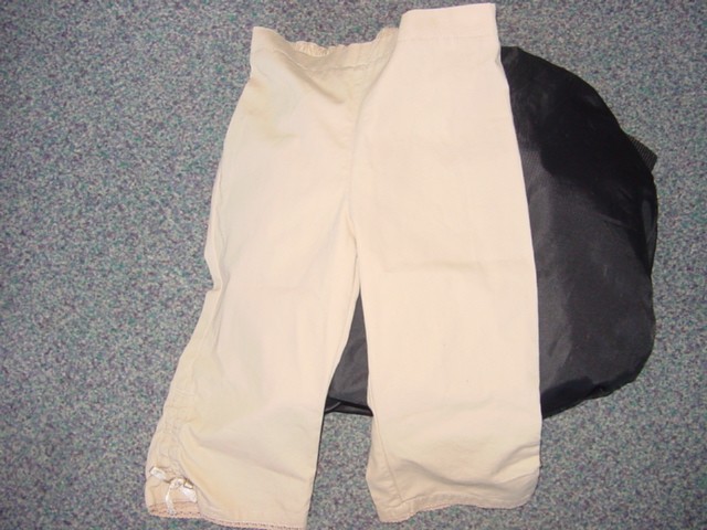 A PAIR OF WOVEN TROUSERS DESIGNED FOR A CHILD OF 86CMS OR LESS. THE TROUSERS HAVE BOW DETAIL AT THE BOTTOM OF EACH LEG WHICH IS TRIMMED WITH COTTON LACE. ELASTICATED WAIST AT THE BACK.PACKAGED AS A RETAIL SET WITH A COTTON TOP WHICH HAS BEEN CLASSIFIED SEPARATELY. MADE OF 100% COTTON.