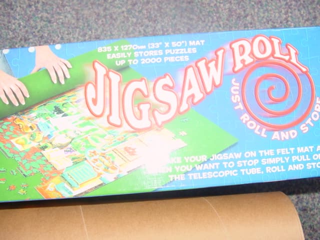 AN ACCESSORY TO A JIGSAW COMPRISING FELT MAT TO LAY A JIGSAW ON WHEN PIECING TOGETHER. WHEN PARTIALLY COMPLETED THE JIGSAW  CAN BE STORED AWAY BY ROLLING AROUND THE CARDBOARD TELESCOPIC TUBE AND FELT MAT. PACKAGED FOR RETAIL SALE IN A CARDBOARD BOX.
