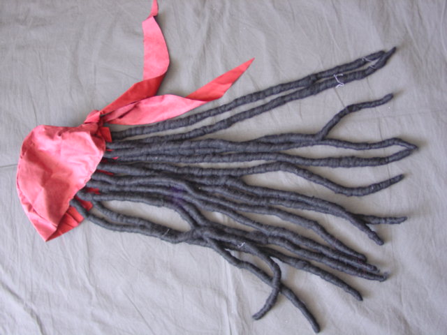 WOVEN POLYESTER HAT IN THE STYLE OF A SCARF WITH ATTACHED HAIR IN DREADLOCKS.  IMPORTED AS PART OF A GHOSTSHIP PIRATE FANCY DRESS COSTUME PACKAGED TOGETHER IN A POLY BAG WITH A PLASTIC POPPER. WITH A PRINTED CARDBOARD INSERT.
