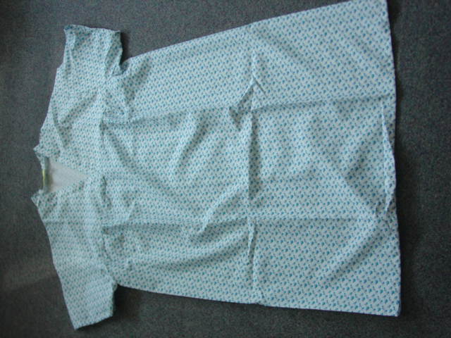 A WOVEN FIRE-RETARDENT POLYESTER NIGHTDRESS FOR USE IN HOSPITALS. FOR WOMEN. WITH A V NECK WITH RIGHT OVER LEFT PLACKET. WITH SHORT SLEEVES. WITH A BACK VENT. INTENDED TO COVER THE BODY FROM THE SHOULDER TO MID-CALF.