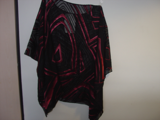 WOVEN KAFTAN STYLE BLOUSE FOR WOMEN.  DESIGNED TO COVER THE BODY FROM THE SHOULDERS TO THE THIGH.  WITH A LOOSE ROUND NECK WITHOUT OPENING.  THE GARMENT IS MADE FROM ONE PIECE OF FABRIC AND HAS VERTICAL STITCHING EACH SIDE SO THE ARMS MAY GO THROUGH TO GIVE SLEEVE EFFECT.  COLOURED LINES ZIG ZAG PATERN.  OVERSEWN AT THE EDGES. BOUND AT NECK EDGE.  65 PERCENT SILK 35 PERCENT COTTON
