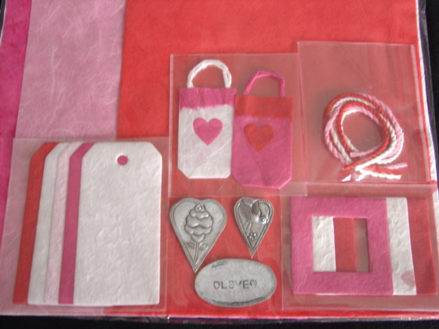 HAND MADE PAPER KIT. SIX SHEETS OF HAND MADE PAPER THREE SHORT LENGTHS OF CORD AND  AN ASSORTMENT OF PAPER SHAPES AND THREE METAL MOTIFS.  ALL PACKAGED AS A KIT FOR SCRAPBOOK/CARD MAKING.