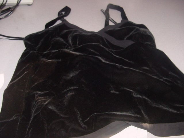 A LADIES WOVEN VELVET CAMISOLE BLOUSE WITH CROSS OVER FRONT AND CHIFFON TRIM. FITS BELOW THE WAIST.ZIP FASTENING AT THE SIDE. 80 % VISCOSE 20% NYLON