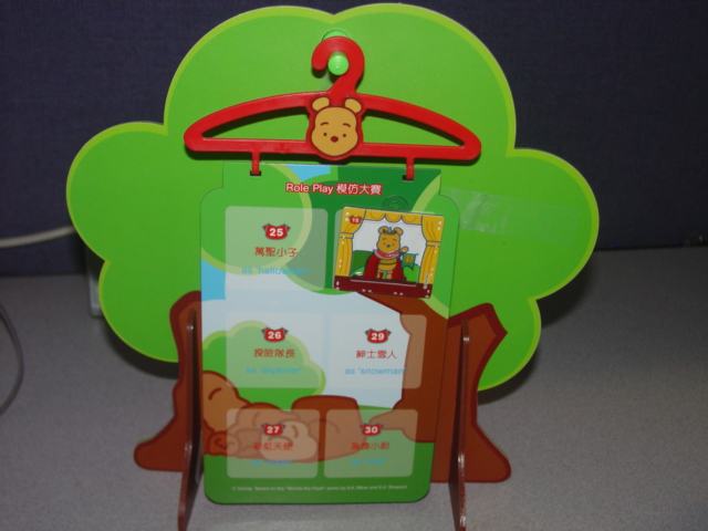 A TOY REPRESENTING A TREE HOUSE. OF PLASTIC. THE TREE COMES WITH 5 MAGNETIC PLASTIC HANGING BOARDS IN THE FORM OF A COAT HANGER THAT ARE DESIGNED TO BE HUNG FROM THE TREE. EACH BOARD HAS SIX DIFFERENT NUMBERED ROLE CHARACTERS, 30 IN ALL (SAILOR, EXPLORER, SNOWMAN, CHEF ETC). THERE ARE 30 MAGNETIC MINI FRAMES PICTURES OF WINNIE THE POO DRESSED IN DIFFERENT OUTFITS (SOLD SEPARATELY) WHICH ARE THEN TO BE COLLECTED AND PLACED IN THE CORRESPONDING ROLE ON THE HANGING BOARDS.