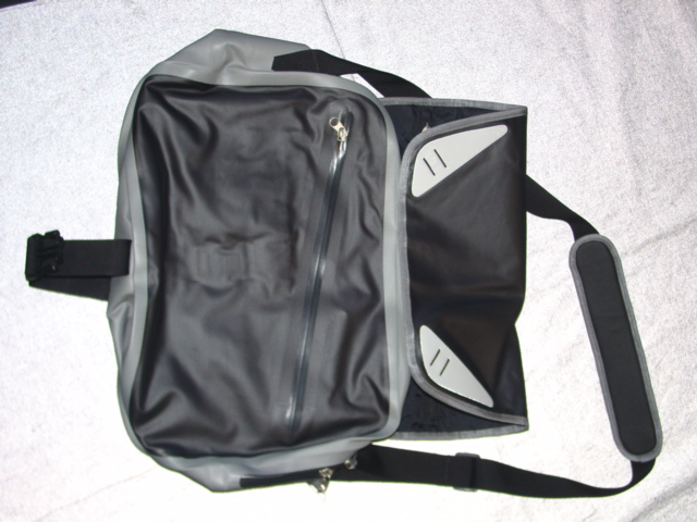 WEATHERPROOF NAVIGATOR BAG (SATCHEL STYLE). CONSTRUCTED OF WOVEN NYLON WITH PU COATING.  OUTER SURFACE CONSIDERED TO BE PREDOMINANTLY OF PLASTIC SHEETING. WITH PADDED TEXTILE ON BACK OF BAG. WITH FLAP FASTENING BY PLASTIC CLIP.  WITH VARIOUS INNER AND OUTER POCKETS, SOME FASTENED BY ZIP.  WITH MOULDED HANDLE ON BACK. WITH SHOULDER STRAP OF TEXTILE WEBBING.  WITH APPLIED LOGO ON FLAP.