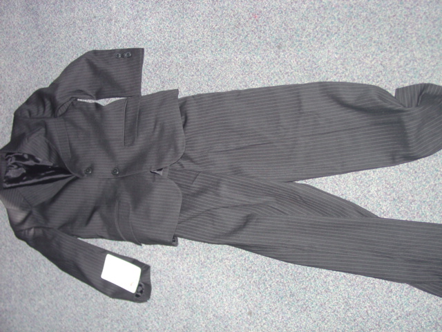 WOVEN TWO PIECE SUIT FOR  BOYS. UPPER GARMENT: JACKET WITH COLLAR. INTENDED TO COVER THE UPPER PART OF THE BODY TO THE HIPS. COMPRISING OF 4  PANELS, 2 AT THE FRONT AND 2  AT THE BACK. WITH A SLIT AT THE BACK AT THE BASE. WITH COMPLETE OPENING AT THE FRONT, FASTENING LEFT OVER RIGHT WITH 2 BUTTONS . WITH A SMALL SLIT POCKET ON THE LEFT CHEST. WITH 2 FURTHER POCKETS WITH FLAPS ON EACH SIDE OF THE LOWER PART OF THE JACKET. WITH LONG SLEEVES WITH 3 BUTTON TRIM AT EACH CUFF. FULLY LINED. WITH 2  INSIDE POCKETS. LOWER PART OF THE GARMENT: PAIR OF TROUSERS INTENDED TO COVER  THE LOWER PART OF THE BODY FROM THE WAIST TO THE ANKLES. ENVELOPING EACH LEG SEPARATELY. WITH FLY OPENING FASTENED BY A ZIP PROTECTED BY A FLAP AND LEFT OVER RIGHT BUTTON FASTENING. WITH A PARTIAL ELASTICATED WAISTBAND AND BELT LOOPS. WITH 2 SLIT SIDE POCKETS. BOTH GARMENTS MADE OF IDENTICAL FABRIC. 99 PER CENT POLYESTER, 1 PER CENT RAYON.