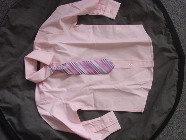 BOYS WOVEN SHIRT AND MATCHING NECK TIE. PUT UP AS A SET. DESIGNED TO COVER THE UPPER PART OF THE BODY FROM THE SHOULDERS TO THE HIPS. COMPLETE FRONT OPENING. LEFT OVER RIGHT BUTTON FASTENING. WITH A COLLAR. WITH LONG SLEEVES WITH BUTTON CUFFS. HEMMED AT THE BASE. THE NECK TIE HAS VELCRO FASTENING AT THE BACK OF THE NECK. 100 PER CENT POLYESTER.