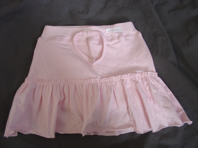 KNITTED SKORT FOR GIRLS. DESIGNED TO COVER THE LOWER PART OF THE BODY FROM THE WAIST TO ABOVE THE KNEE. WITH TIGHT FITTING SHORTS ATTACHED AND TOTALLY COVERED BY AN OVERSKIRT. WITH AN ELASTICATED WAIST.  WITH A DECORATIVE, NON FUNCTIONAL TIE AT THE FRONT OF THE WAIST.  HEMMED AT LEG ENDS. WITH A ROUGH EDGE AT THE BASE OF THE SKIRT. 96 PERCENT COTTON 4 PERCENT ELASTANE