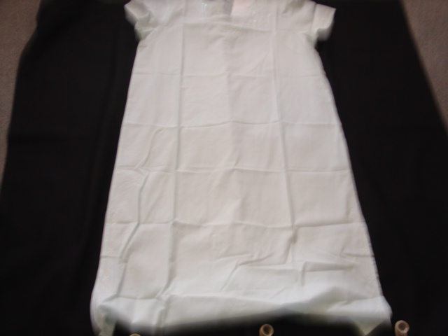 WOVEN NIGHTDRESS FOR LADIES REACHING FROM THE SHOULDERS TO MID CALF. WITH VEE SHAPED NECKLINE. WITH SHORT SLEEVES HEMMED AT SLEEVE ENDS. HEMMED AT BASE OF GARMENT WITH SLITS AT SIDE SEAMS WHICH ARE TRIMMED IN EMBROIDERY AND SEQUINS AT THE FRONT. FRONT OF NECKLINE AND SLEEVE ENDS DECORATED WITH EMBROIDERY AND SEQUINS. 100 PER CENT COTTON.