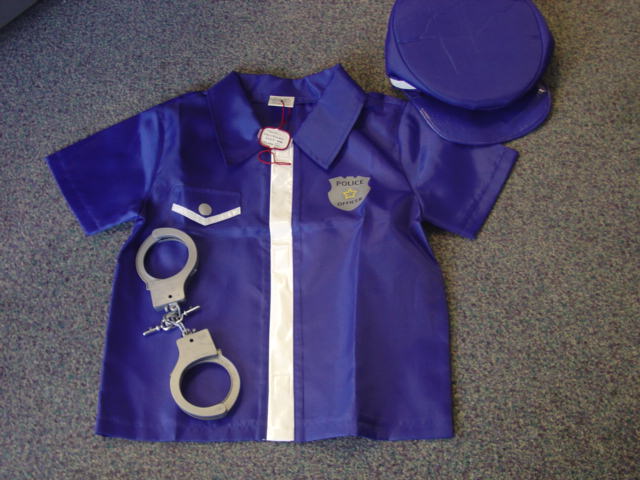 WOVEN FANCY DRESS SHIRT FOR CHILDREN. DESIGNED TO COVER THE UPPER PART OF THE BODY FROM THE SHOULDERS TO THE HIP. WITH COLLAR. WITH SHORT SLEEVES. WITH VELCRO FASTENING WITH PLASTIC EDGING. WITH FAKE POCKET FLAP AND PRINTED POLICE OFFICER LOGO ON CHEST. OF POLYESTER.  PACKAGED TOGETHER WITH A HAT MADE OF THE SAME MATERIALS AND TOY PLASTIC HANDCUFFS.